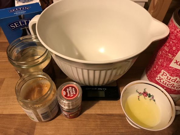 Alle Zutaten für ketogene Mandel-Kokosmus-Kekse – Mandelmus, Kokosmus, Eiweiß, Erythrit und Gewürze bereitgestellt.