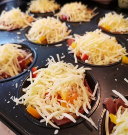 Käse auf die Muffins streuen